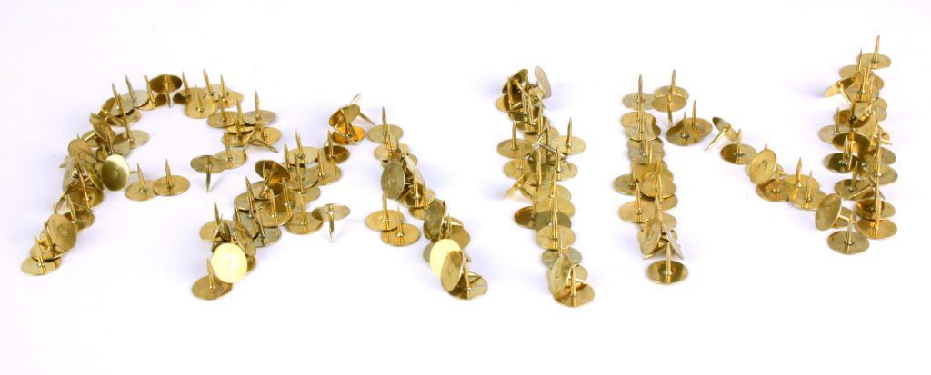 The word pain spelled in brass tacks.