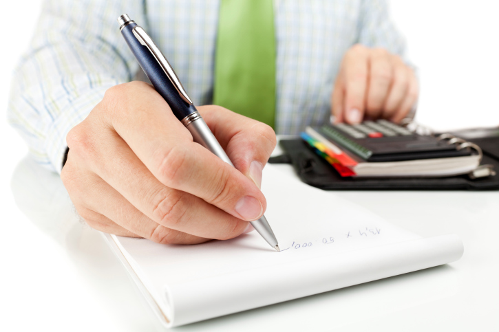 Accountant using calculator and ledger.