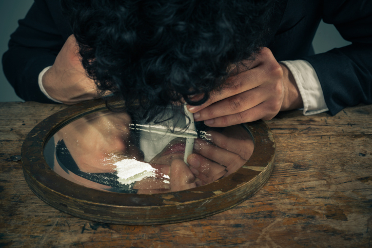 Businessman face down snorting cocaine.
