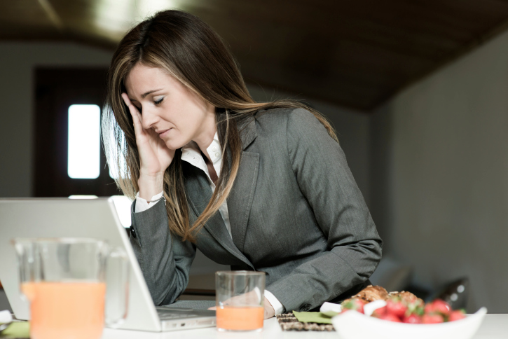 Hung over businesswoman falling asleep at her desk.