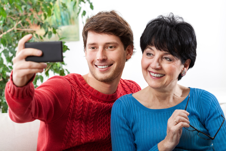 Mother and adult son taking a selfie together.