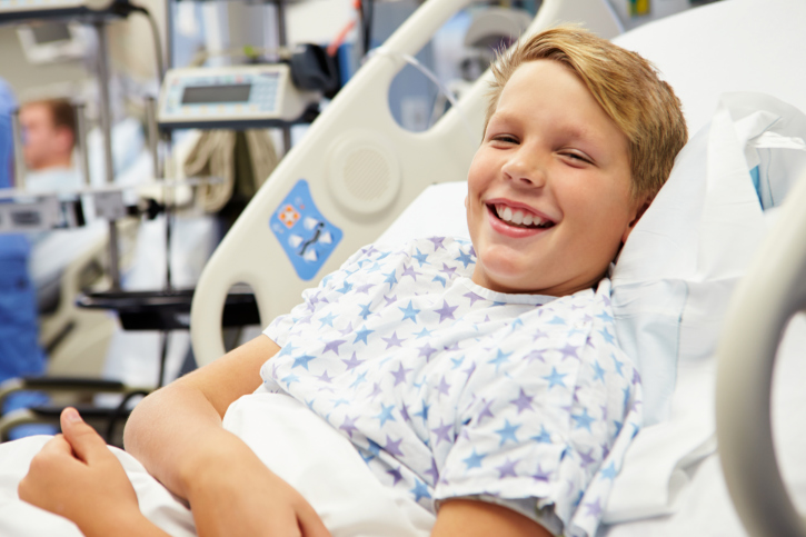 Young boy lying in hospital bed.