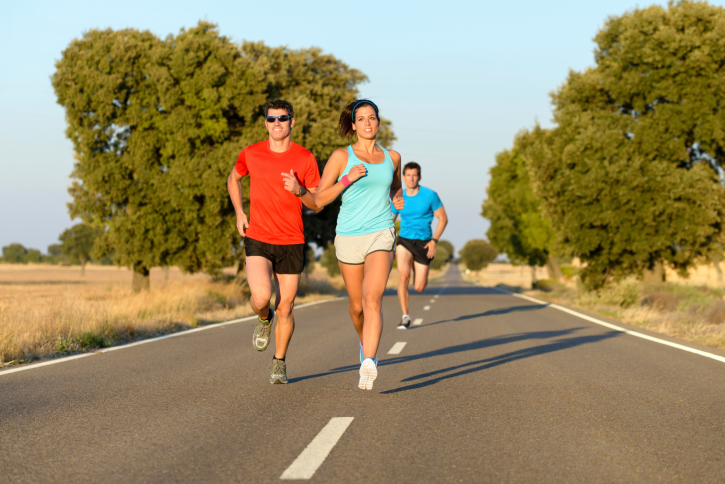 Young men and women running a marathon.