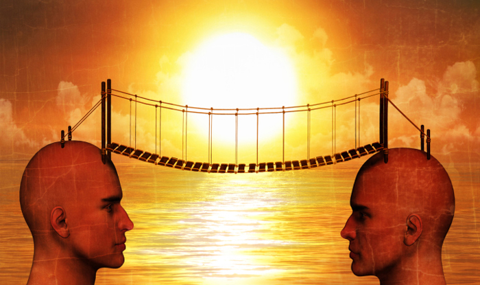 illustration of 2 opposite facing heads connected by a bridge over the water at sunrise