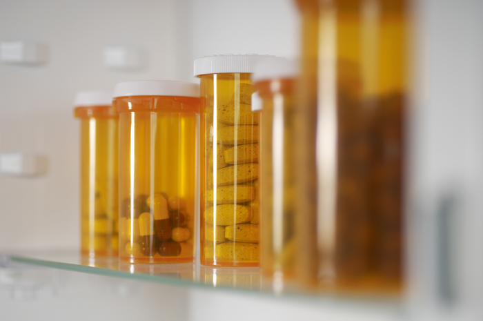 unlocked medicine cabinet showing bottles of prescription pills