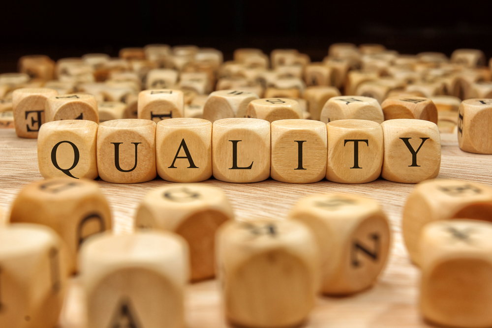 photo of wood dice with letters that spell out the word QUALITY