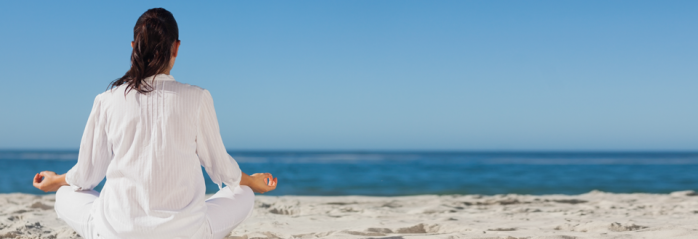 woman meditating on the beach
