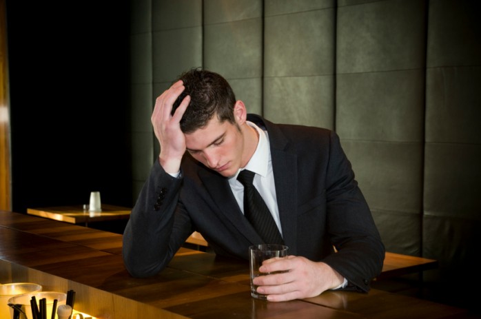 young_alcoholic_businessman_at_bar